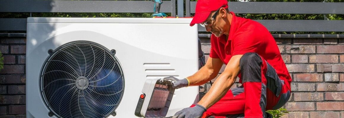Person repariert Wärmepumpe mit Werkzeugkasten.